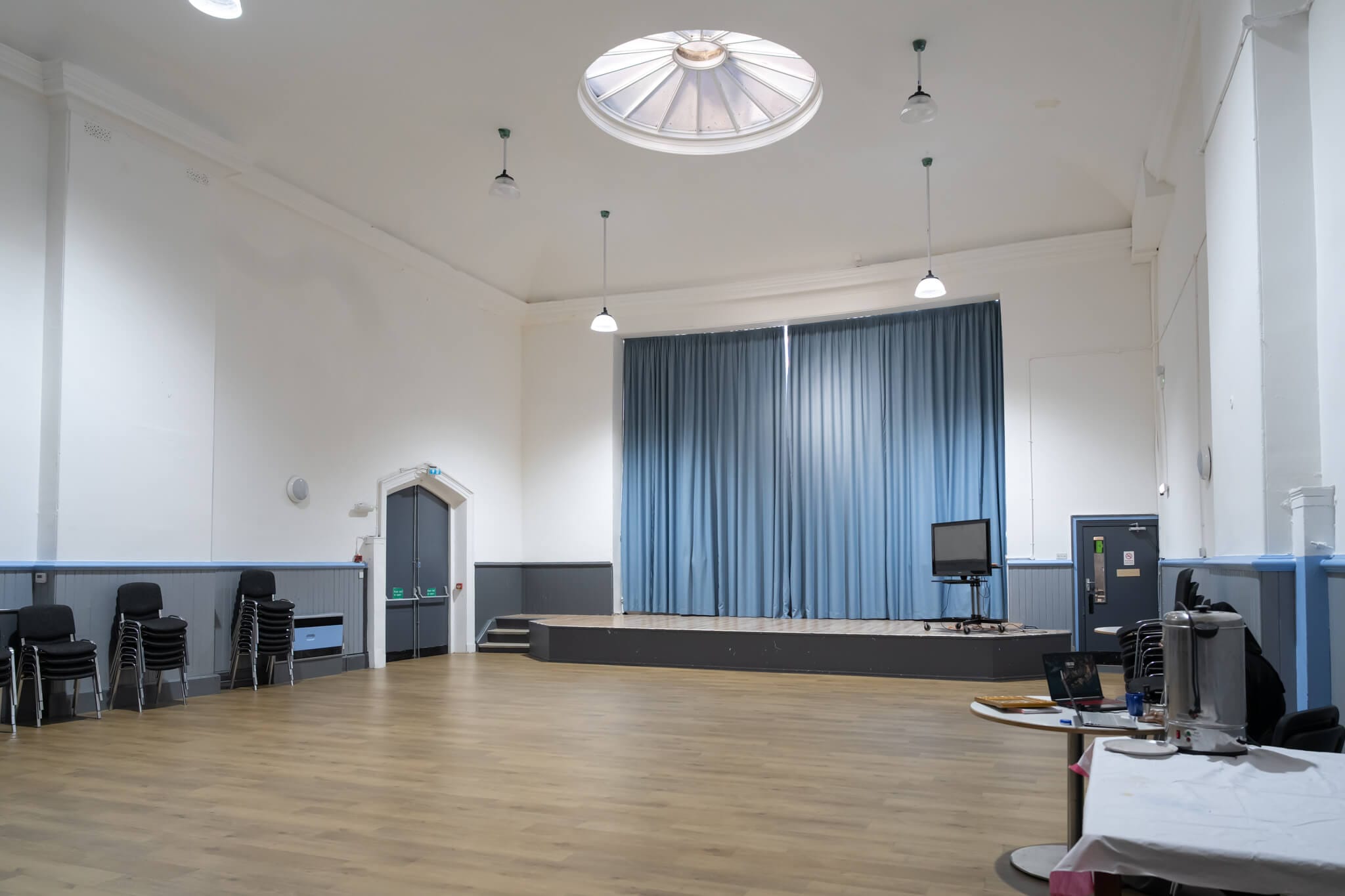 The bright main hall at Israac with its stage and community space